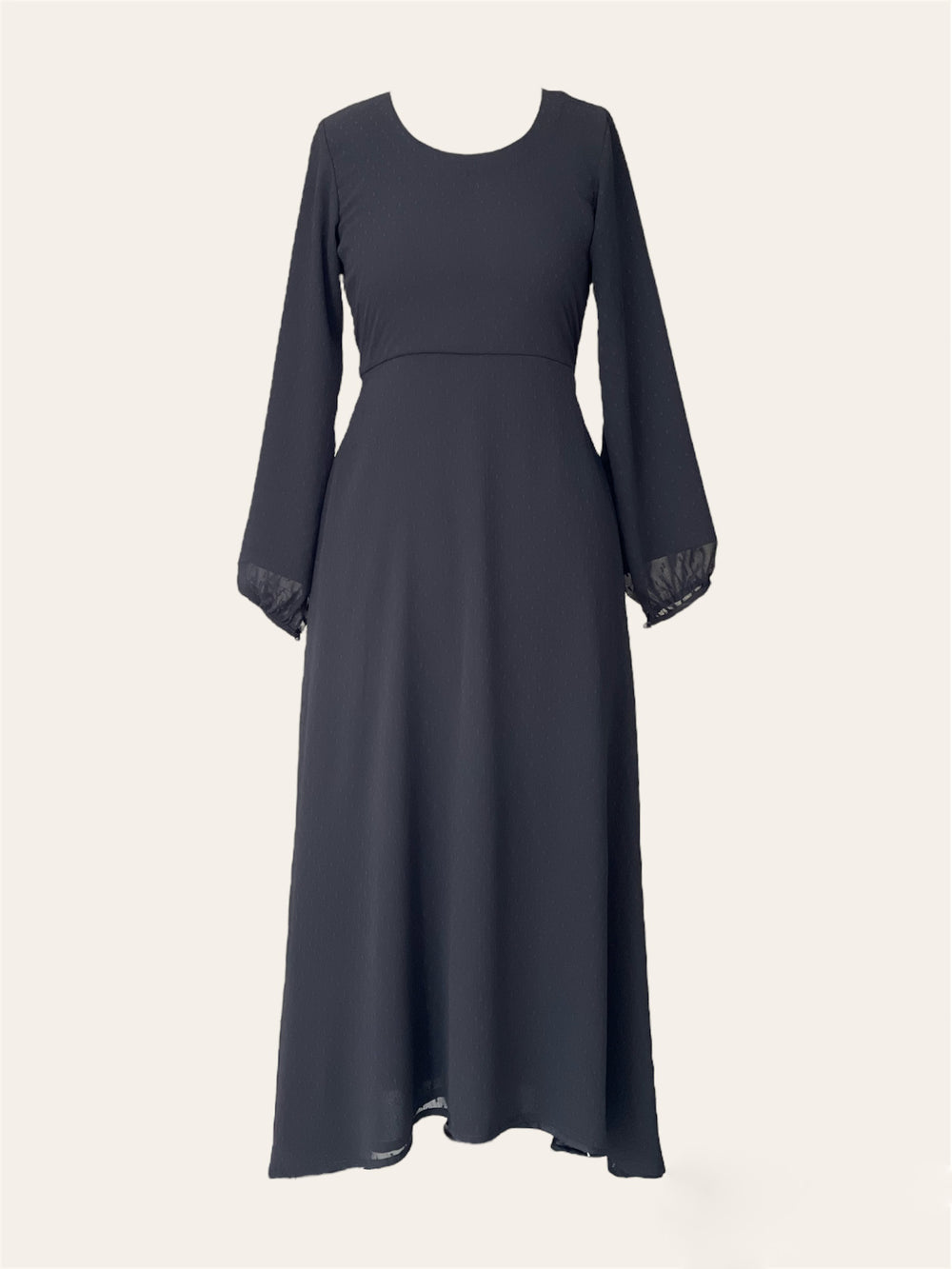 A long black dress with a scoop neckline and long, slightly puffed sleeves. The dress features a fitted bodice that transitions into a flowing skirt, with subtle texture detailing on the fabric. The sleeves end in a gentle, elasticized gather.